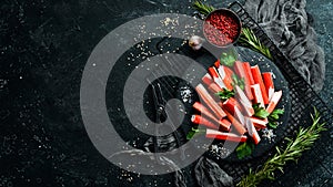 Crab sticks from a crab on a black stone plate.