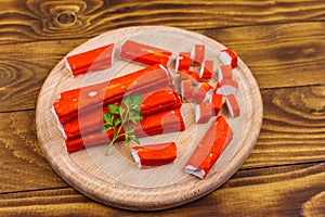 Crab sticks on cutting board on wooden table