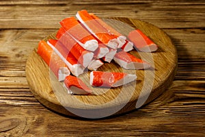 Crab sticks on cutting board on wooden table