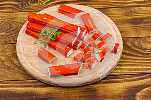 Crab sticks on cutting board on wooden table