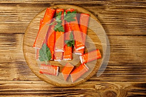 Crab sticks on cutting board on wooden table