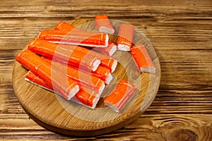 Crab sticks on cutting board on wooden table