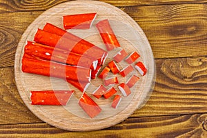 Crab sticks on cutting board on wooden table