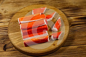 Crab sticks on cutting board on wooden table