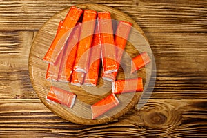 Crab sticks on cutting board on wooden table