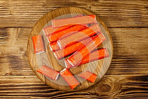 Crab sticks on cutting board on wooden table