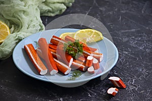 Crab sticks in a plate on a dark background