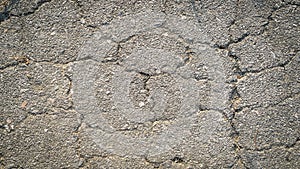 Crack on the asphaltic surface. Natural pattern on textured surface. Ruined of the walkway.