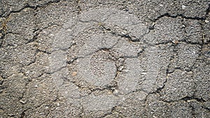 Crack on the asphaltic surface. Natural pattern on textured surface. Ruined of the walkway.