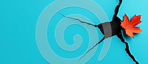 A crack in a blue background with a red maple leaf.