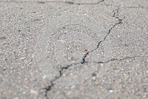 Crack on gray asphalt, close-up, creative background