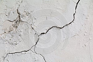 Crack. Texture of old painted white plaster. Cracked wall. photo