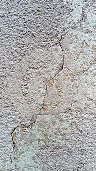 Crack on the wall of the house. Old plaster falls off the surface. Defect during construction. The effect of humidity on the