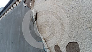 Crack on the wall of the house. Old plaster falls off the surface. Defect during construction. The effect of humidity on the