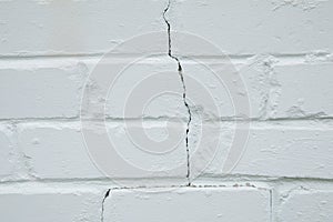 Crack in the white brick wall background