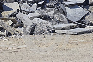 Cracked asphalt pieces after demolition of a road surface in a construction site