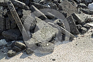 Cracked asphalt pieces after demolition of a road surface in a construction site for renovation ready to be recycled