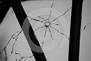 cracked and broken window glass punched by a pistol bullet