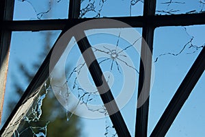 cracked and broken window glass punched by a pistol bullet