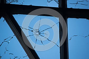 cracked and broken window glass punched by a pistol bullet