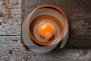 Cracked chicken egg on a wooden table