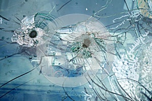 Cracked and chipped broken glass background with bullet holes, war between Ukraine and Russia, february 2022