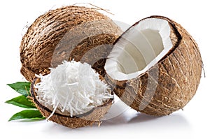 Cracked coconut fruit with white flesh and shredded coconut flakes isolated on white background