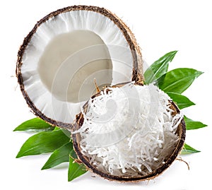 Cracked coconut fruit with white flesh and shredded coconut flakes isolated on white background