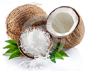 Cracked coconut fruit with white flesh and shredded coconut flakes isolated on white background