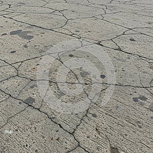 Cracked concrete surface with visible fissures forming irregular patterns photo