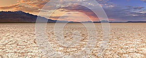 Cracked earth in remote Alvord Desert, Oregon, USA at sunset