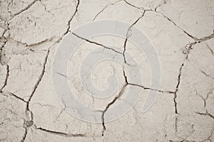 Cracked earth soil ground texture background. Mosaic pattern of dried mud clay earth and sand, top view. The concept of