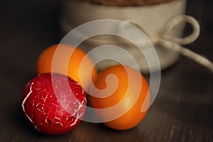 Cracked Easter egg with other colored eggs and Easter cake on wooden table