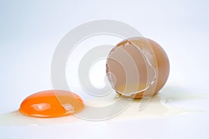 Cracked egg, eggshell with yolk isolated on white background