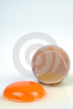 Cracked egg, eggshell with yolk isolated on white background