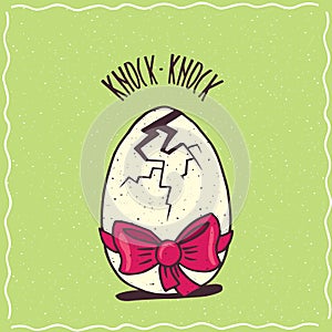 Cracked egg with a red ribbon