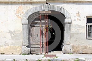 Cracked entrance to old abandoned suburban family house supported with strong metal poles in front of dilapidated large wooden