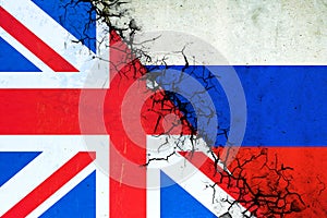 Cracked flags of Russia and England. International political relations. Conflict. Political Economic background.