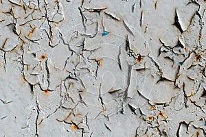 Cracked gray paint on an old metallic surface, rusted gray painted metal wall, sheet of rusty metal with cracked and flaky paint
