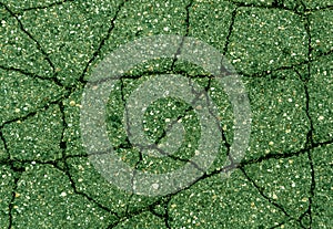 Cracked green asphalt surface.