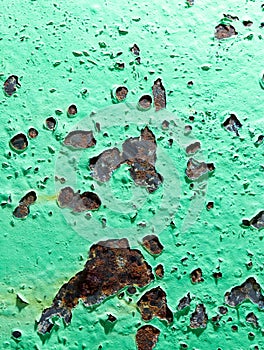 Cracked green paint on rusty metal as abstract background