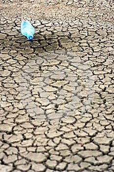 Cracked ground with empy bottle