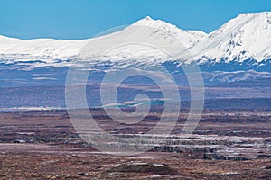 Cracked ground and snow covered mountains in the background