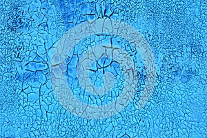 Cracked grunge blue background of old paint. Parched earth pattern