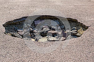Cracked hole in the asphalt road photo