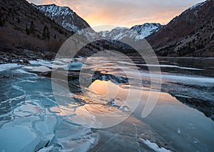 Cracked ice on a frozen lake captures sunset light