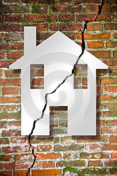 Cracked old and aged broken brick wall with a house drawn on it - concept image