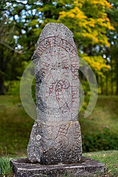 Cracked old rune stone with red runes