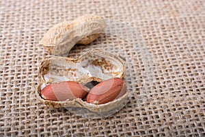Cracked open peanuts with shell on a linen canvas