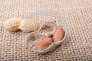 Cracked open peanuts with shell on a linen canvas